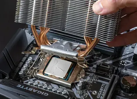 Una persona está instalando un disipador de CPU en una placa base.