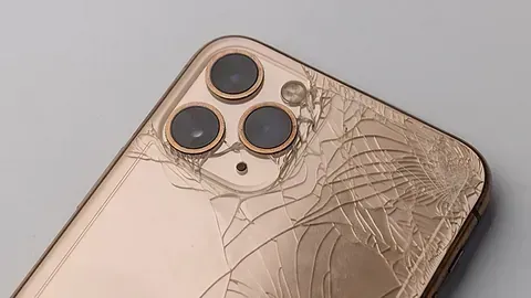 Un primer plano de un iPhone roto sobre una mesa.