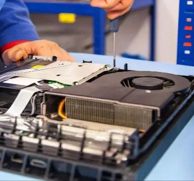 Una persona está arreglando una computadora con un destornillador.