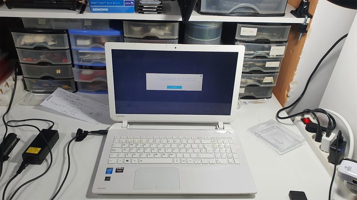 Una computadora portátil blanca está sobre un escritorio blanco.