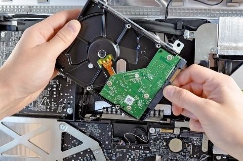 Una persona sostiene un disco duro en sus manos.