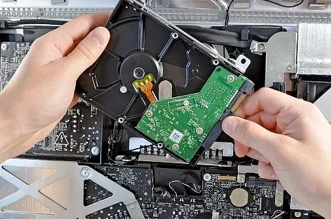 Una persona sostiene un disco duro en sus manos.