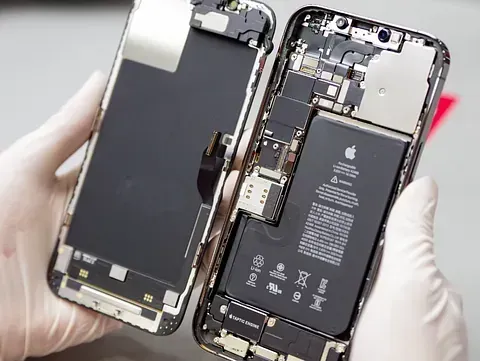 Una persona sostiene un teléfono celular que ha sido desmontado.