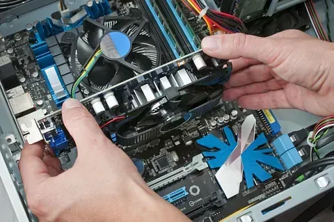 Una persona está instalando una tarjeta gráfica en una computadora.