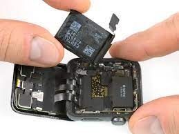Una persona está quitando la batería de un reloj Apple.