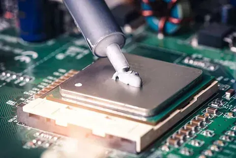 Una persona está aplicando pasta térmica a una CPU en una placa base.