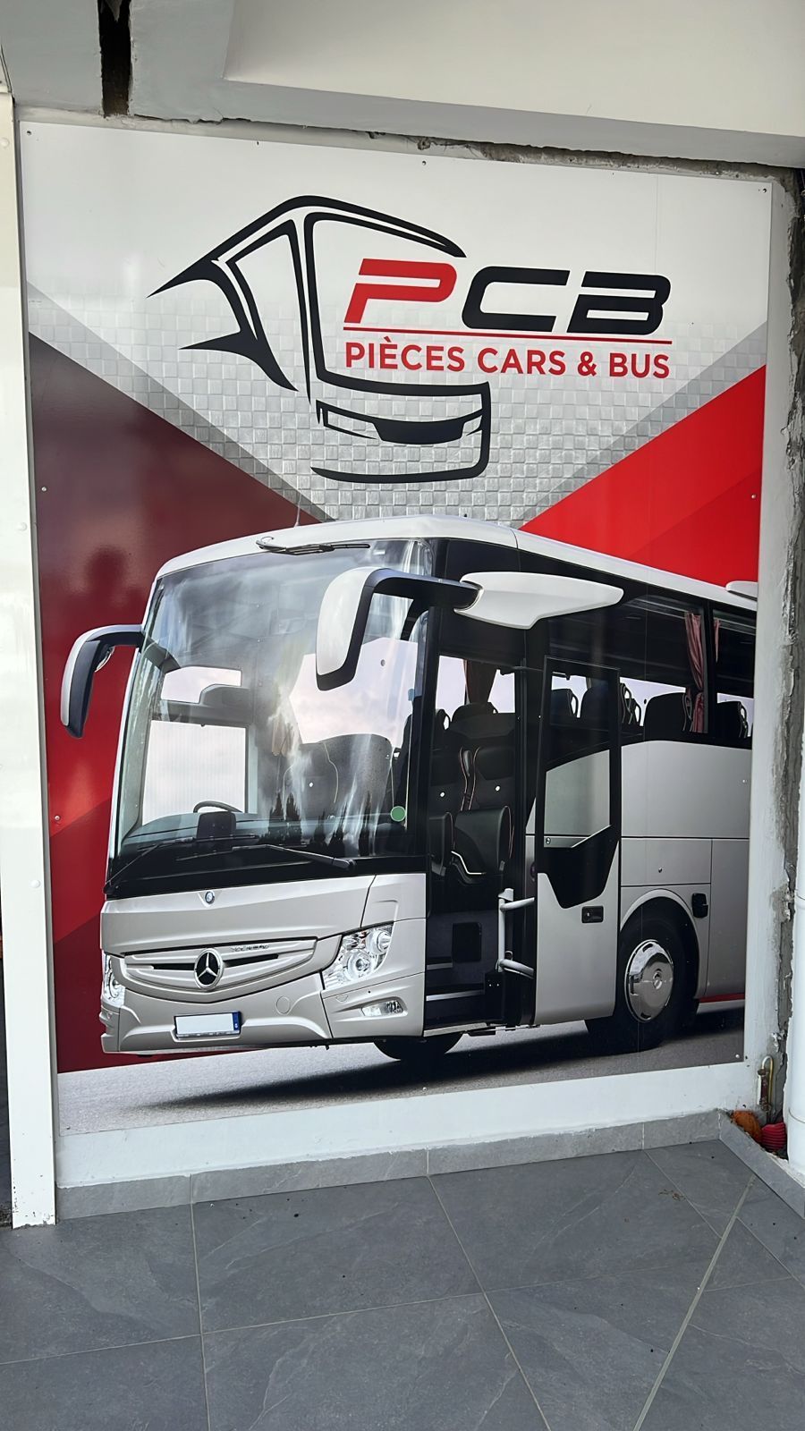 Affiche d'un autocar blanc avec le logo PCB Pieces Cars & Bus et des graphismes rouges et noirs