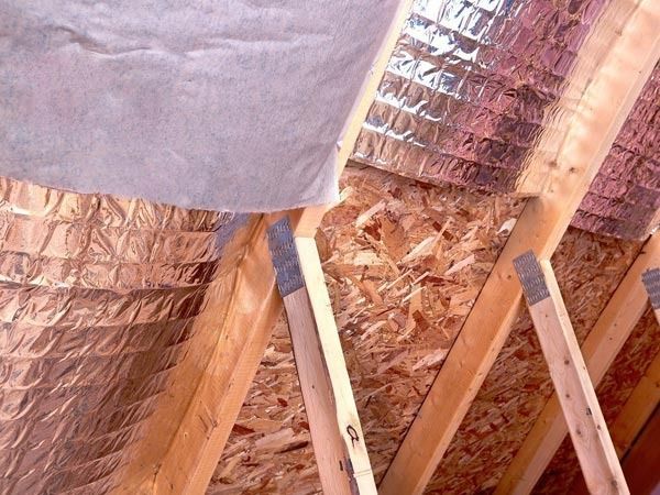 Un techo con papel de aluminio y vigas de madera.