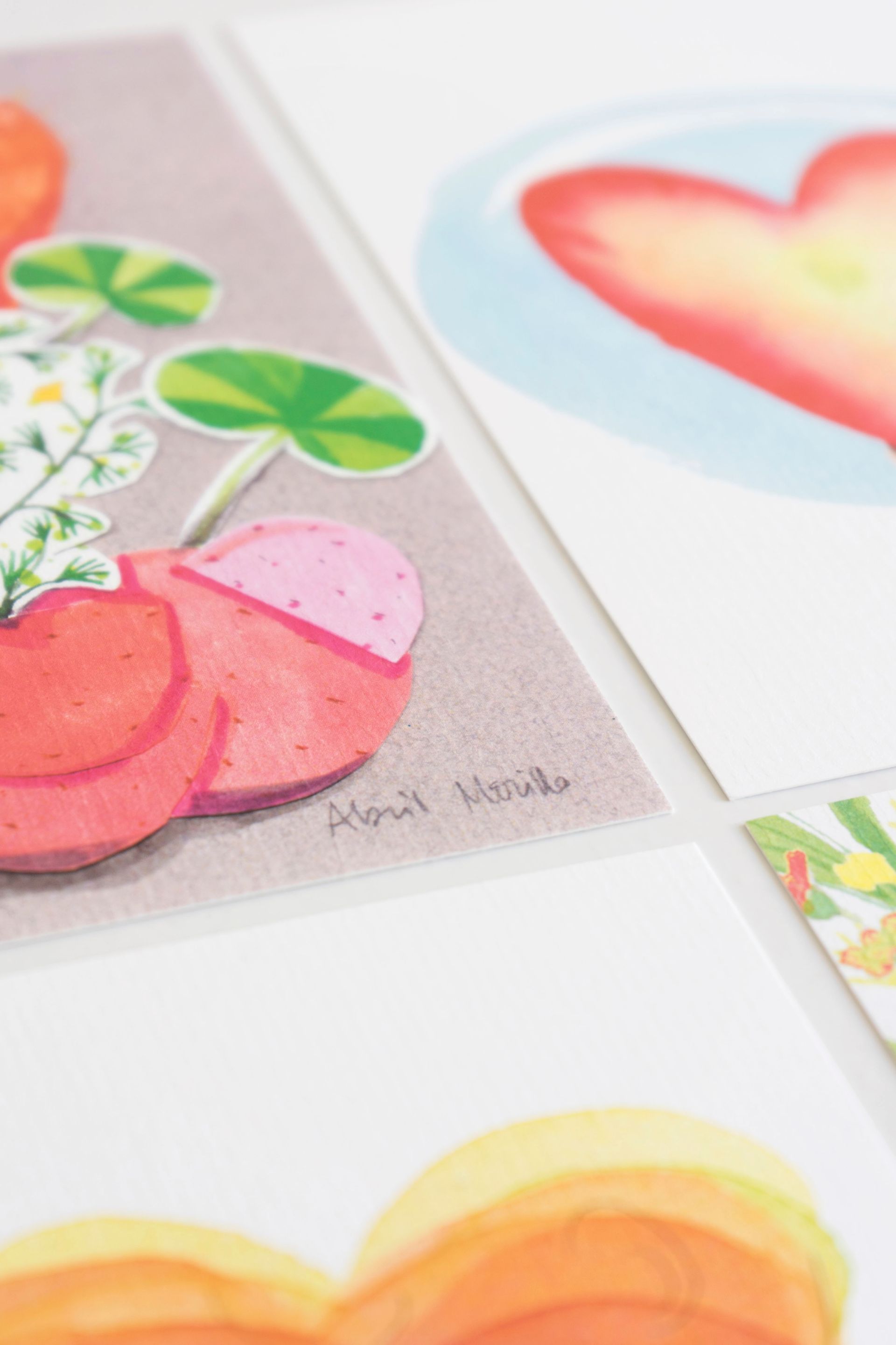 Pinturas de acuarela: frutas, flores y un corazón en colores suaves, sobre cartulinas blancas.