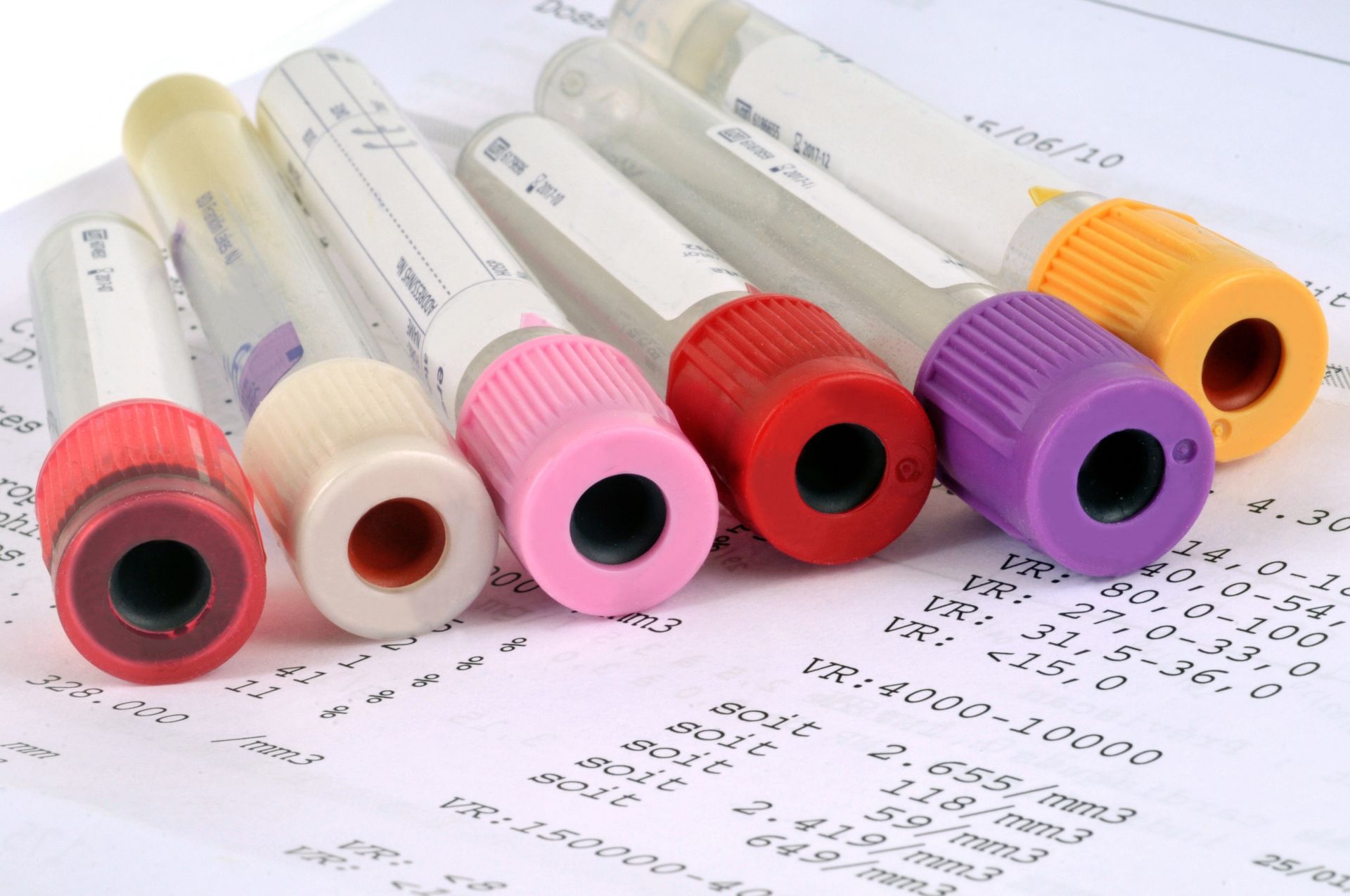 Tubes de prélèvement sanguin colorés sur un rapport d'analyse de laboratoire