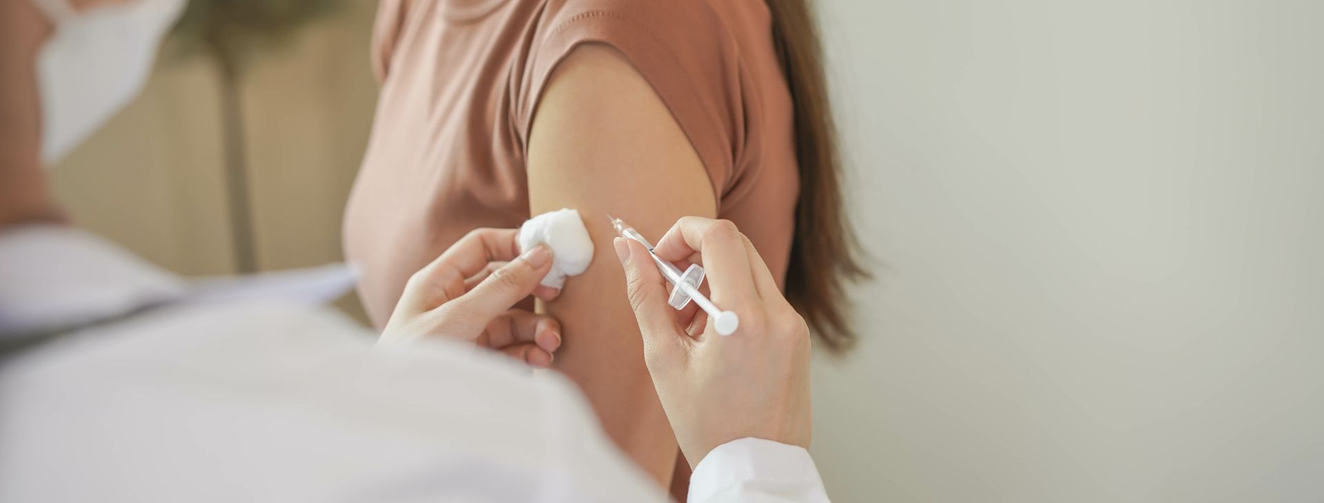 Mains recevant une injection dans le haut du bras par un professionnel de la santé