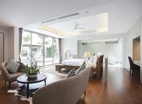 Una sala de estar con un sofá, sillas, una mesa y una cama.