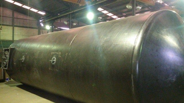 Un gran cilindro de metal se encuentra en un almacén.