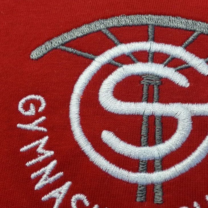 Der Buchstabe S ist auf ein rotes Hemd gestickt