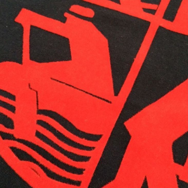 Eine Nahaufnahme eines rot-schwarzen Logos auf schwarzem Hintergrund