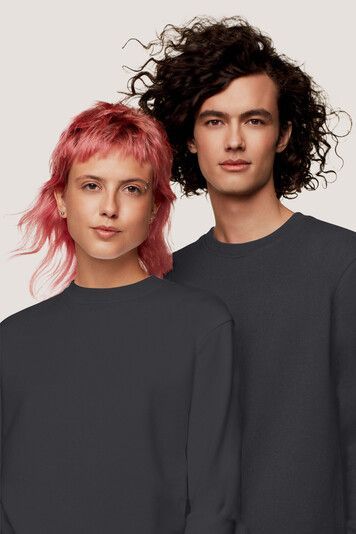 Ein Mann und eine Frau mit rosa Haaren stehen nebeneinander.