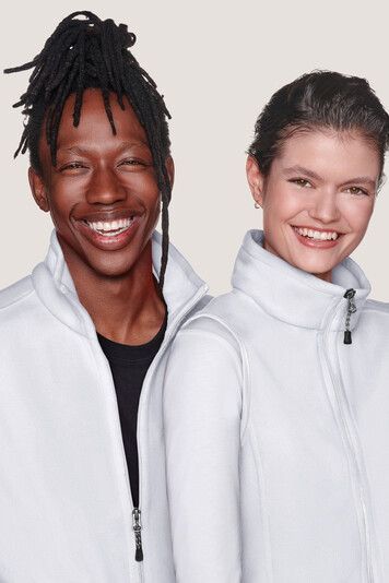 Ein Mann und eine Frau in weißen Jacken lächeln in die Kamera