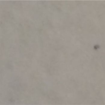 Eine Nahaufnahme einer grauen Oberfläche mit einem schwarzen Fleck darauf.