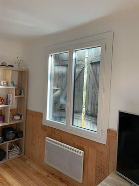 Fenêtre blanche avec des volets en bois fermés