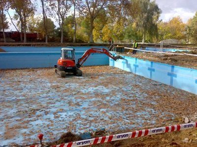 Una pequeña excavadora está trabajando en una piscina.