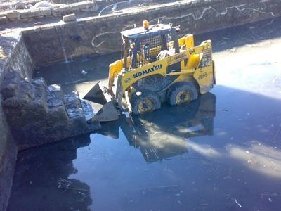 Una excavadora Komatsu amarilla está en el agua