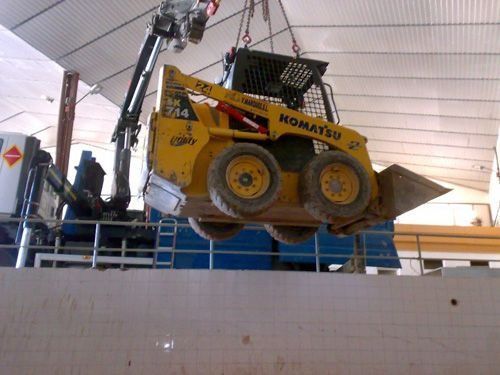 Una excavadora Komatsu está siendo levantada por una grúa