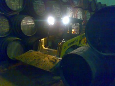 Una excavadora Komatsu amarilla está trabajando en una bodega.