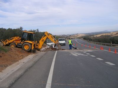 Una excavadora amarilla está parada al costado de una carretera
