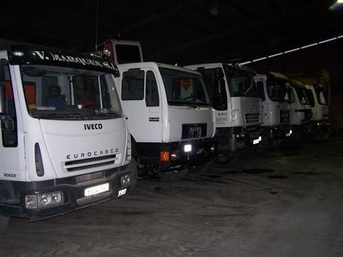 Una fila de camiones Iveco están estacionados en un garaje oscuro
