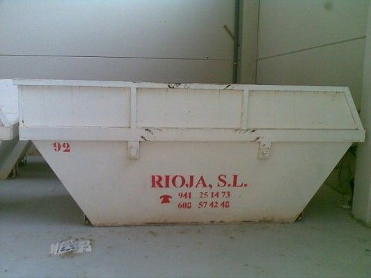 Contenedor industrial blanco con letras rojas “RIOJA, SL” en el interior de un almacén o garaje.