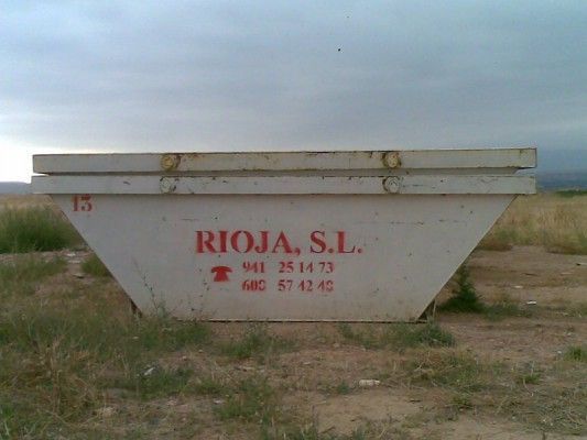 Gran contenedor de basura metálico blanco con las letras rojas