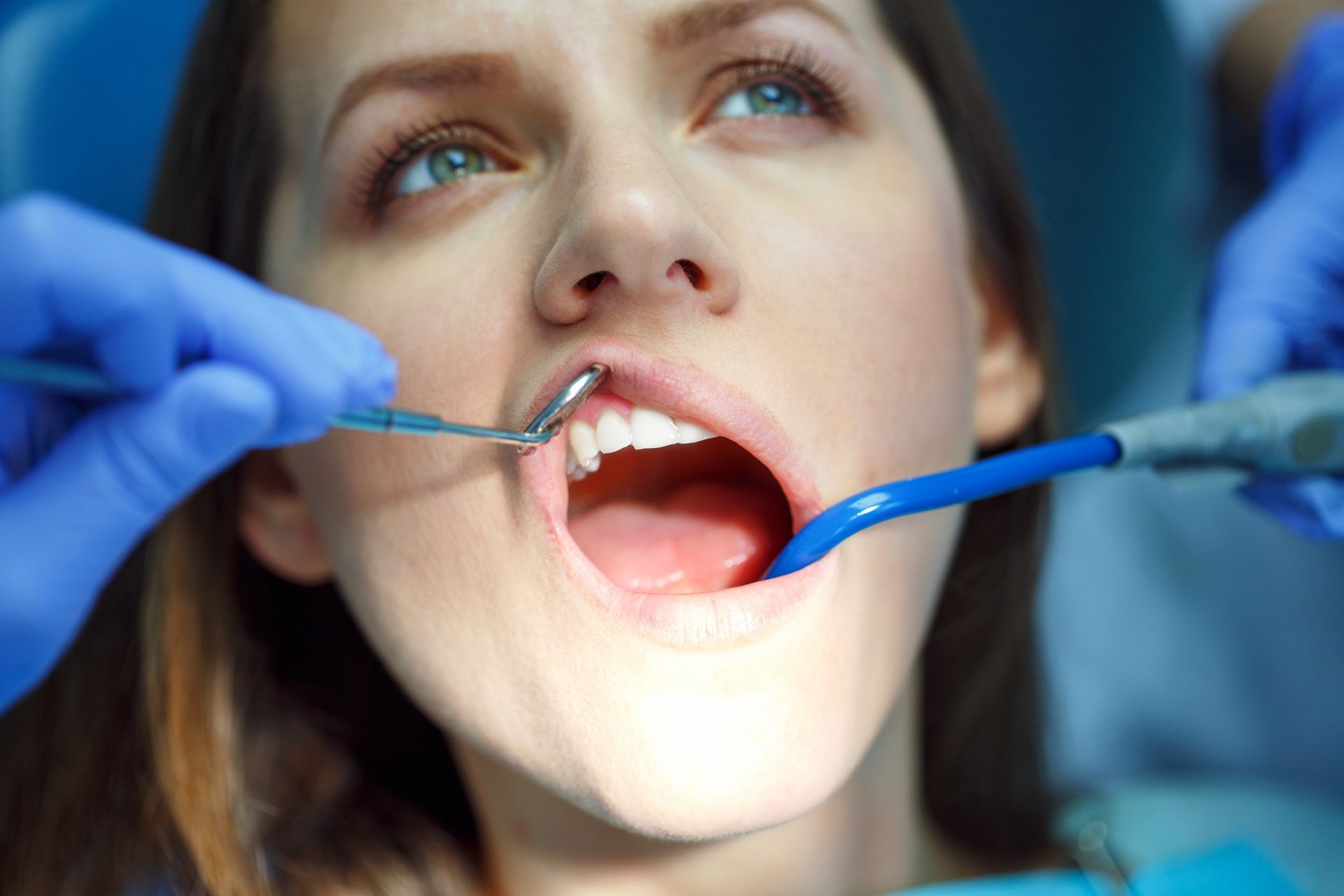 Una mujer está siendo examinada por un dentista.