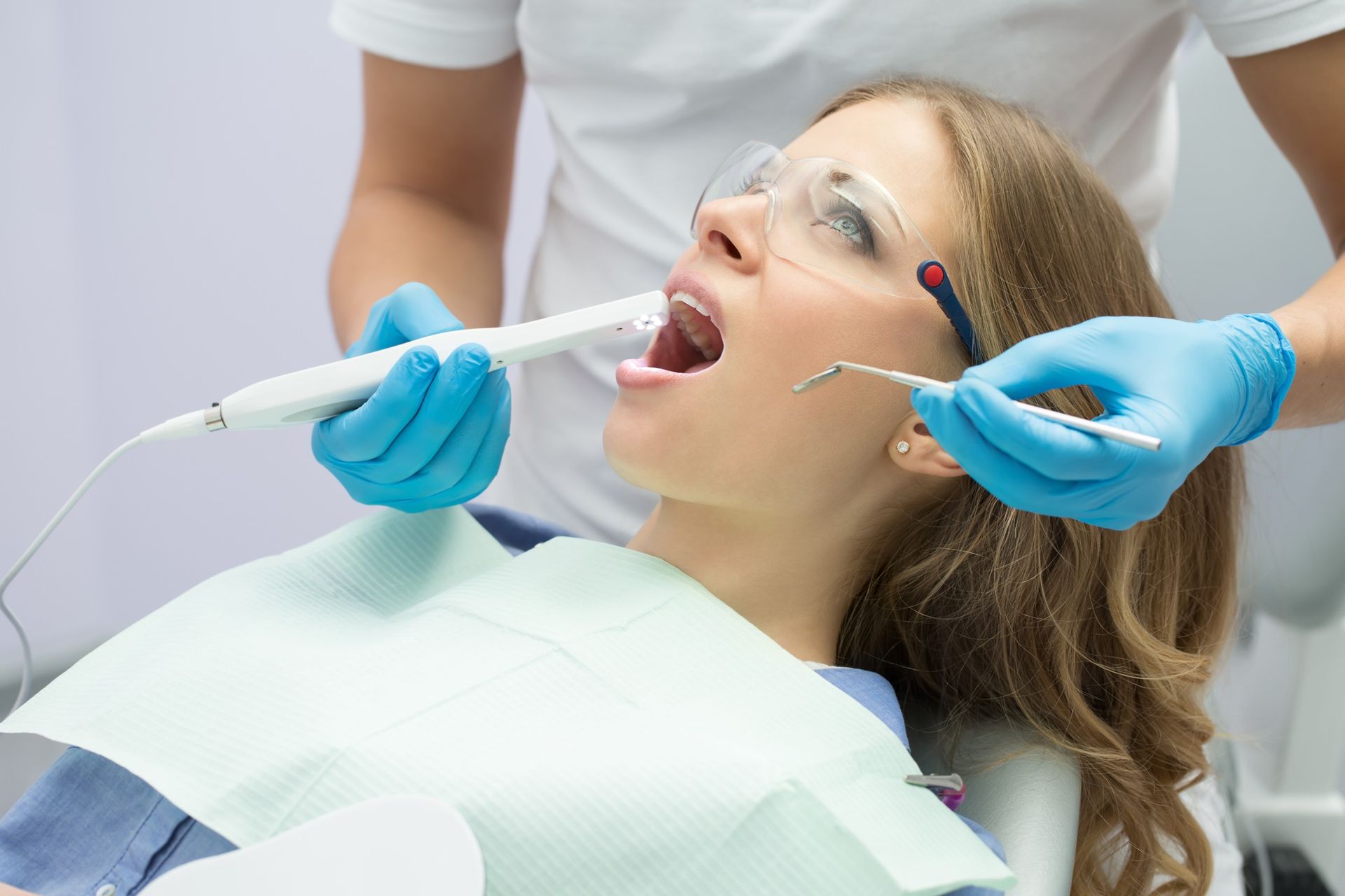 Una mujer está siendo examinada por un dentista.