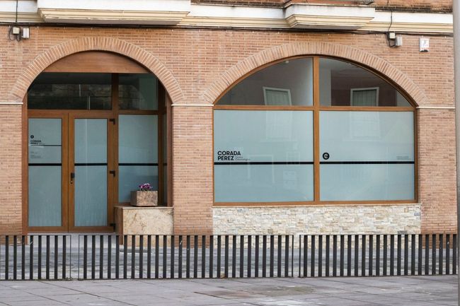 Una mujer sonríe mientras se mira los dientes en un espejo.