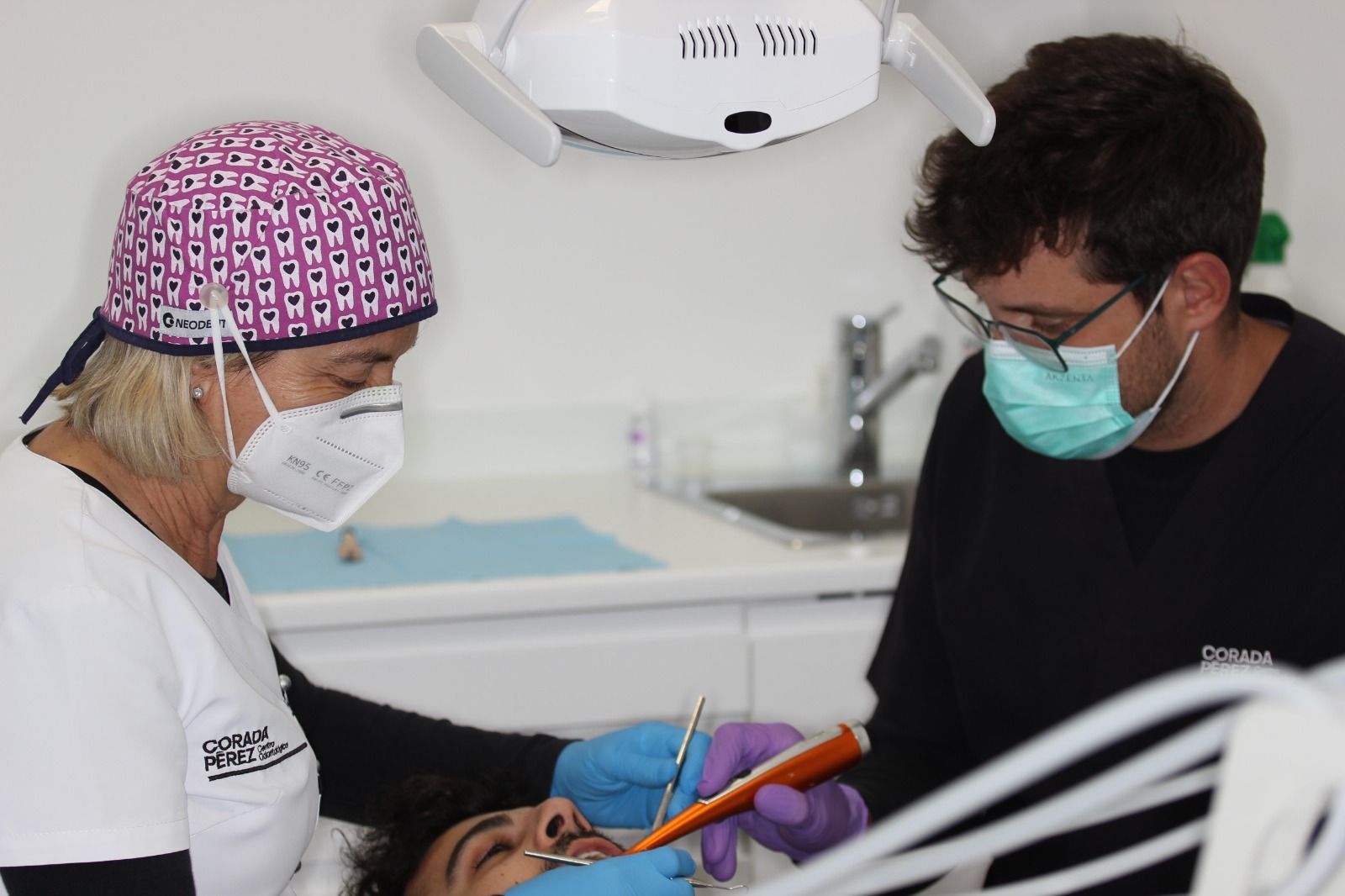 Una mujer sonríe mientras un dentista le examina los dientes.