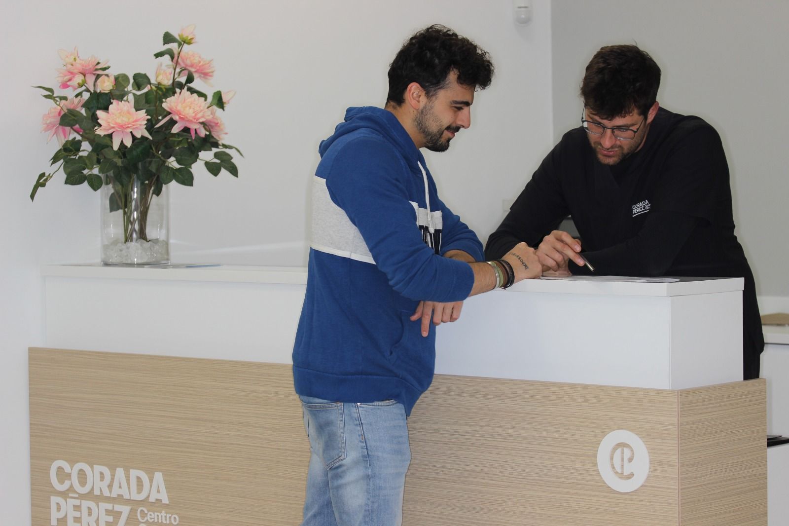 Una mujer está sentada en una silla dental sosteniendo un aparato transparente en su boca.