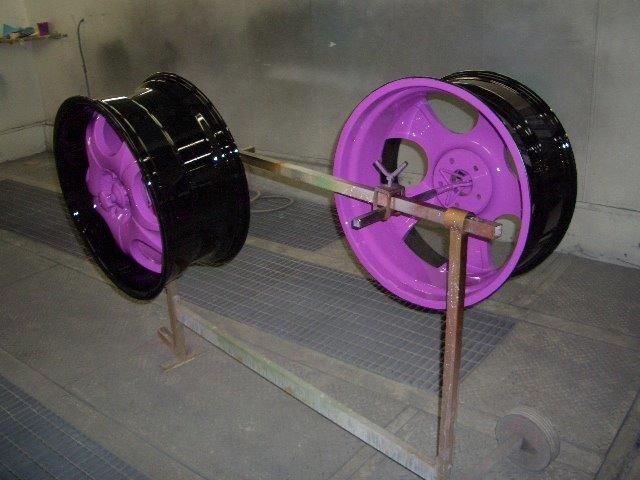 Ein Paar rosa und schwarze Räder auf einem Ständer