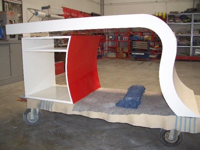Ein weiß-rotes Möbelstück steht auf einem Wagen