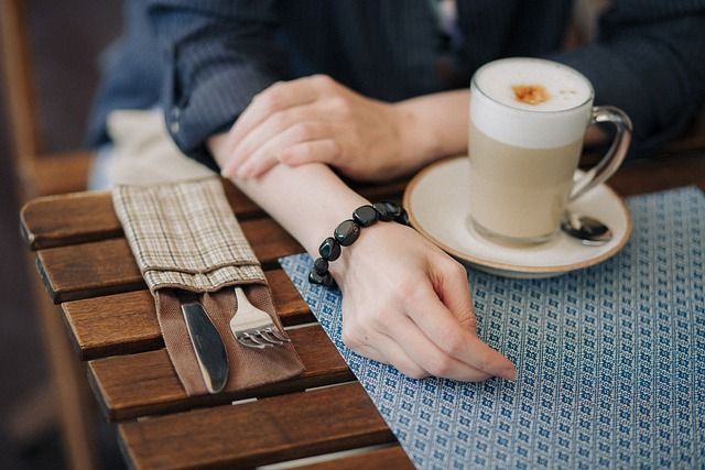 Una mujer está sentada en una mesa con una taza de café.