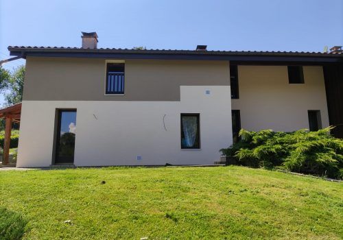 Façade arrière d'une maison peinte en gris et blanc