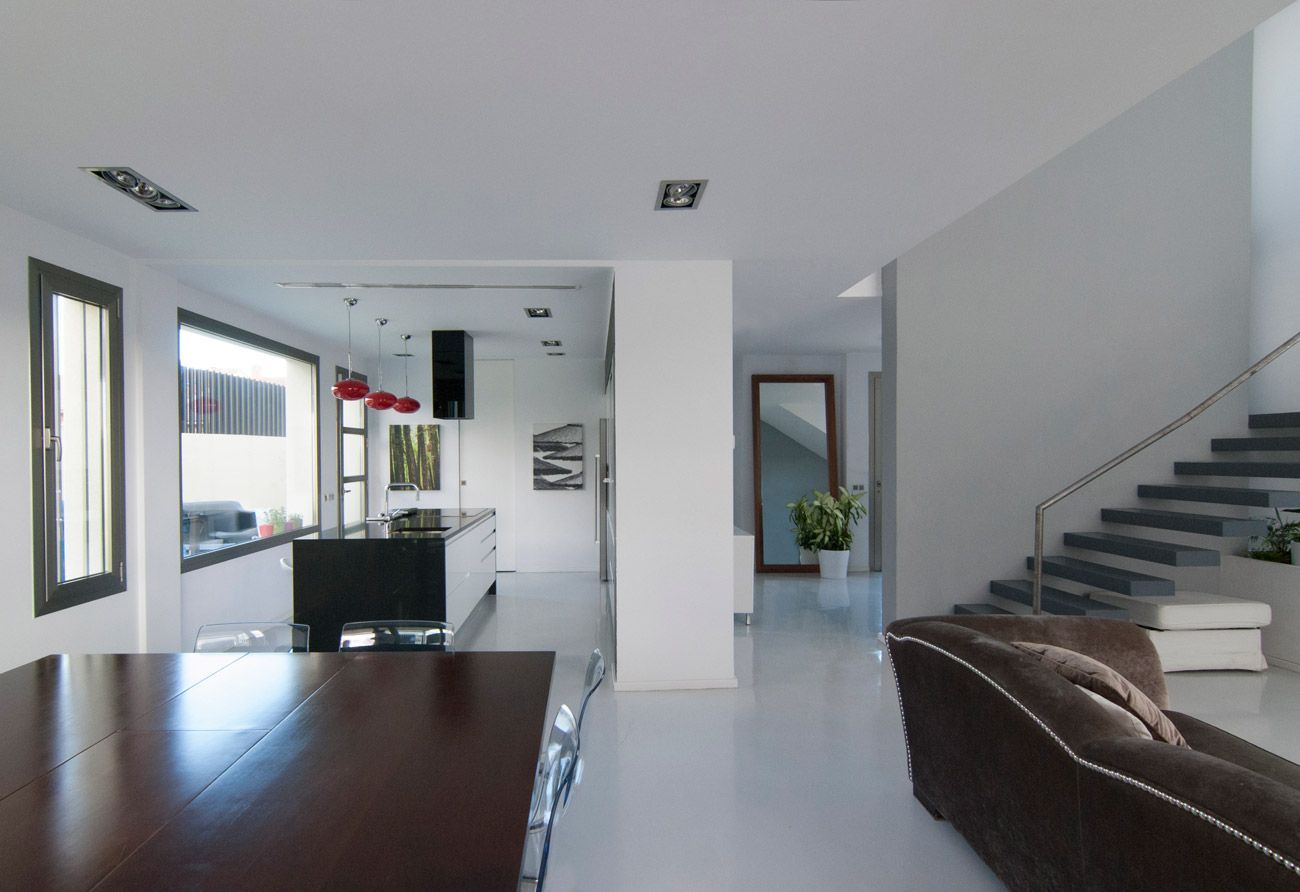 Una sala de estar con un sofá marrón y escaleras.