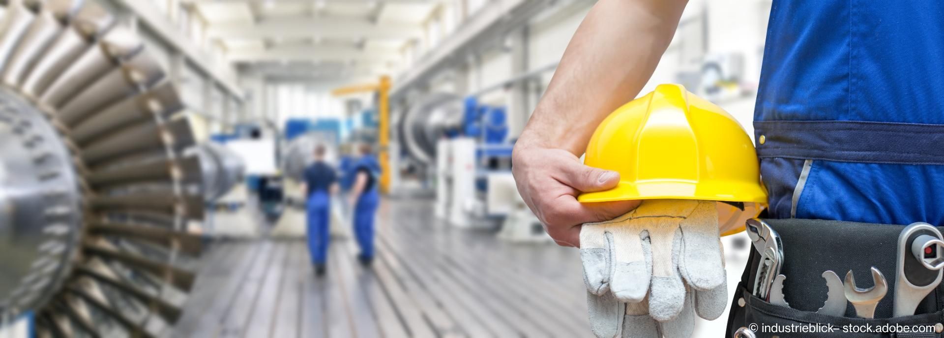 Arbeitsschutz mit Helm und Handschuhen in moderner Werkhalle