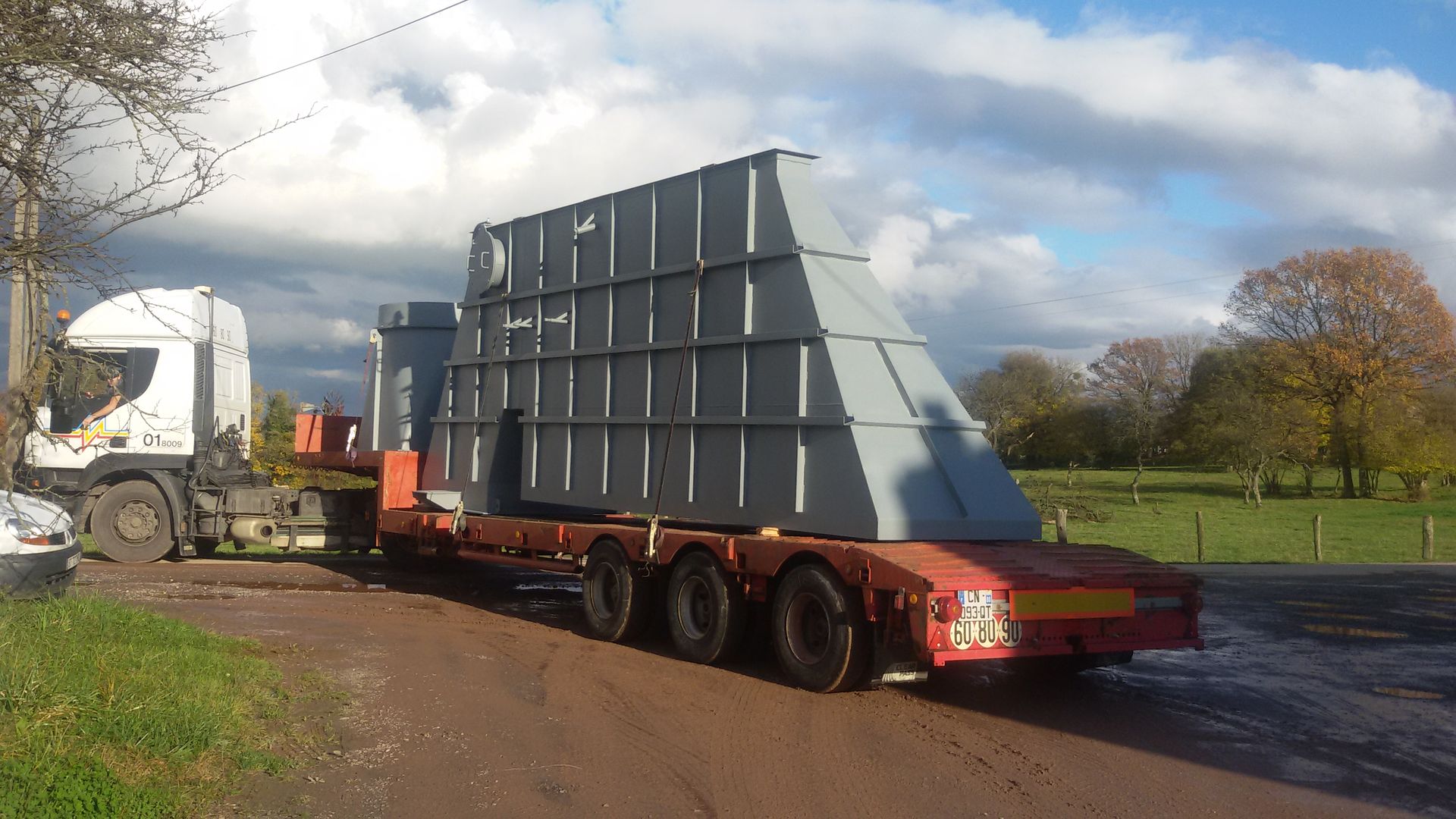 Camion avec une grande pièce métallique sur la remorque