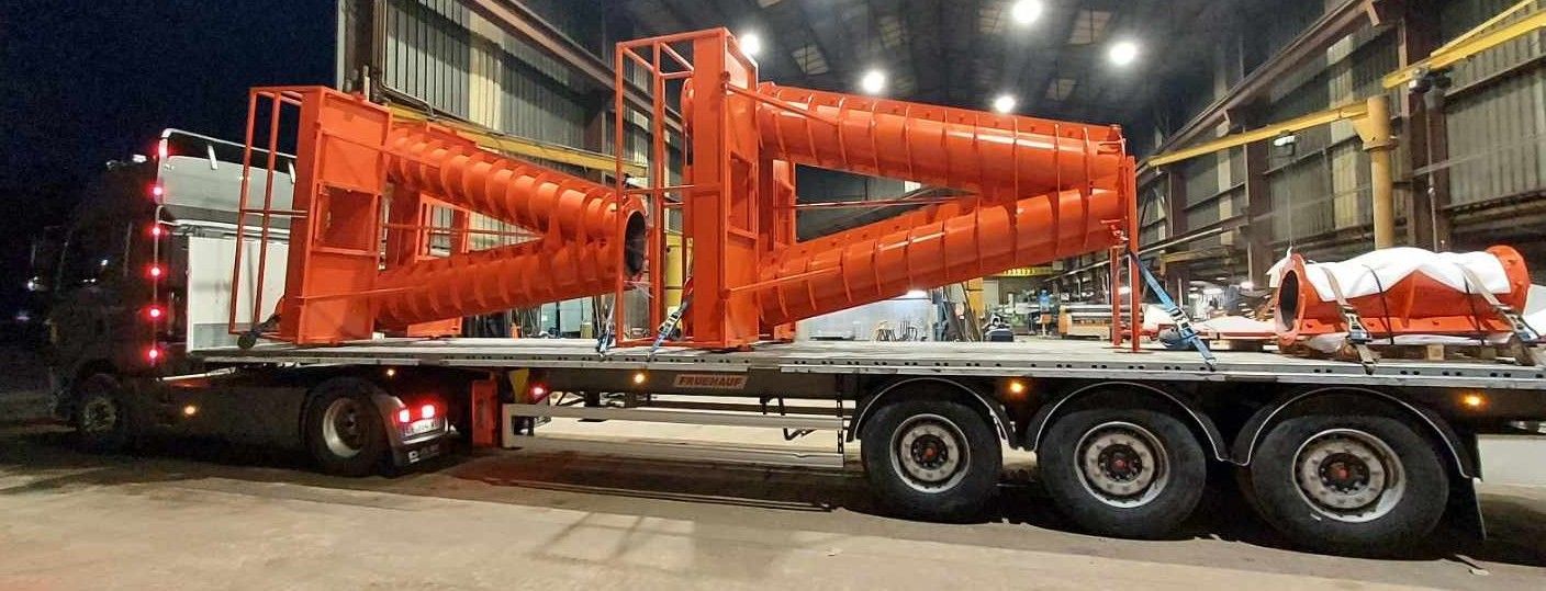 Camion avec de grandes pièces en acier de couleur orange
