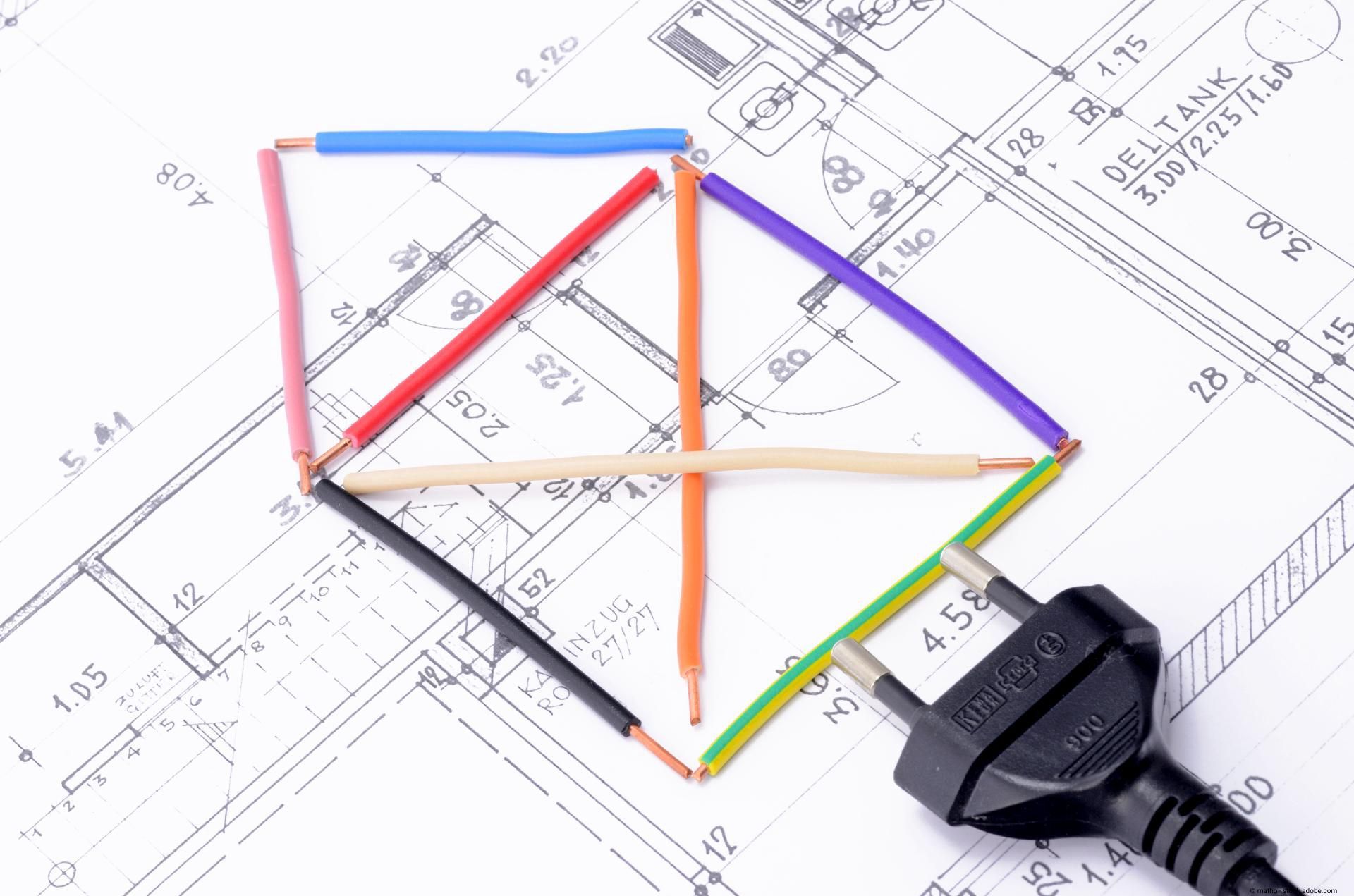 Farbige Kabel formen ein Haus auf einem technischen Bauplan, daneben ein Stromstecker.