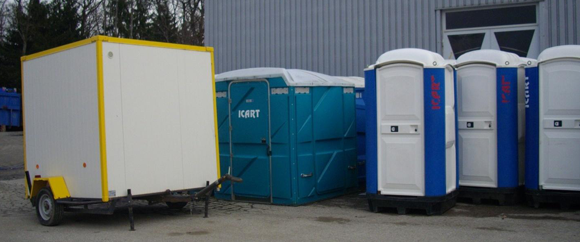 Une remorque blanche à bordures jaunes est garée à côté d'un grand conteneur de stockage portable bleu et d'une rangée de toilettes portables blanches et bleues.