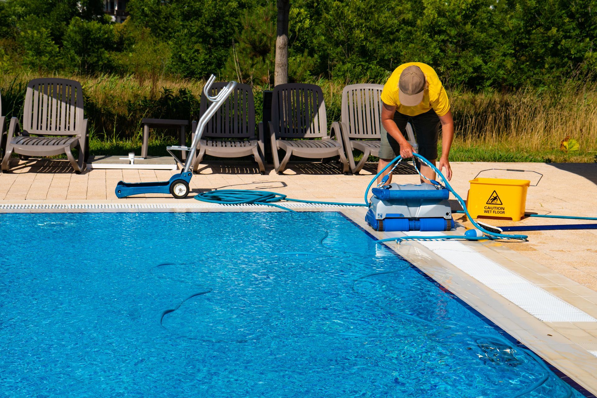 Un technicien qui nettoie une piscine
