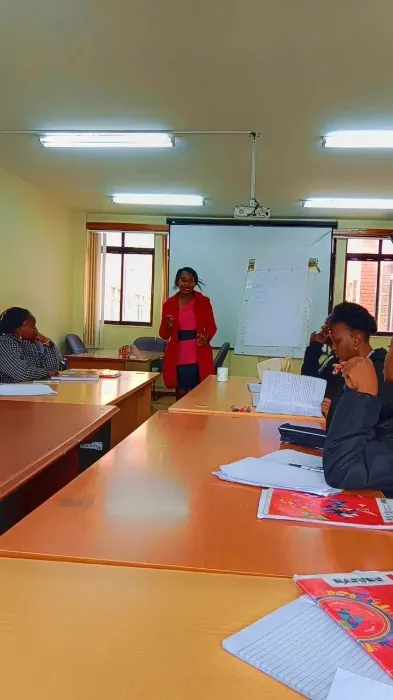 A group of people are sitting at tables in a classroom.