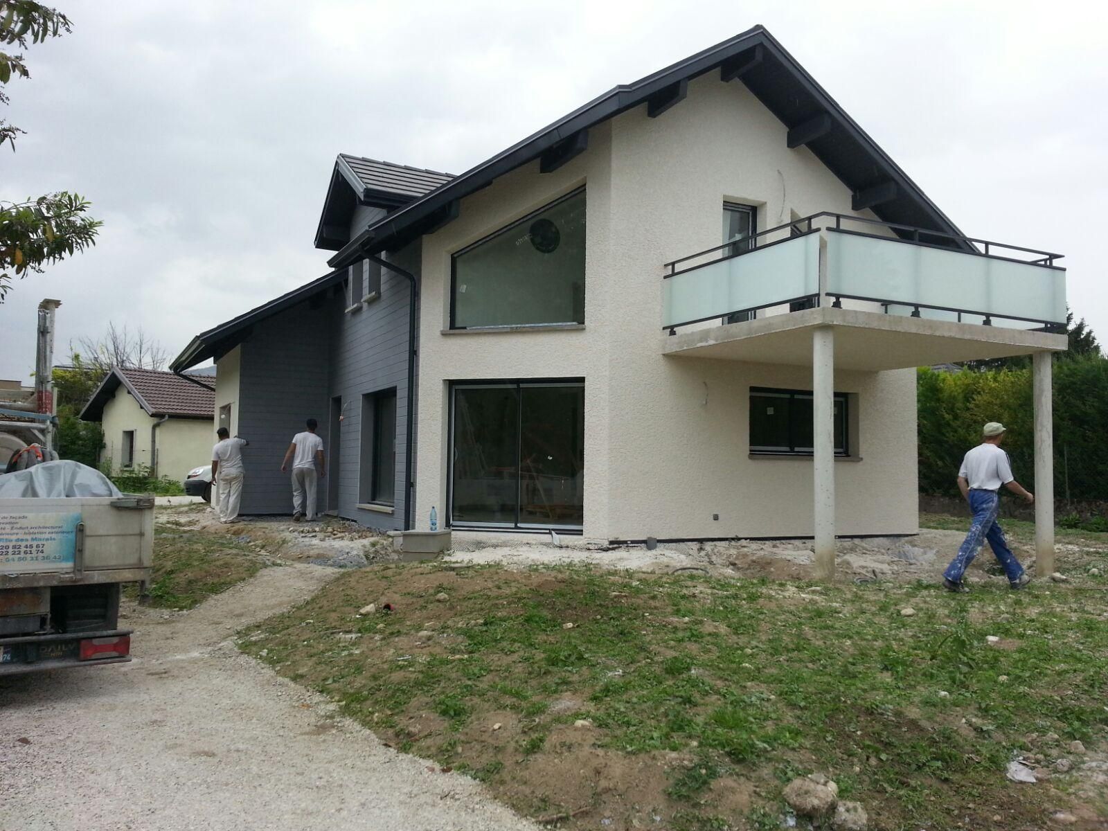 Une maison avec un côté couvert de bardage gris