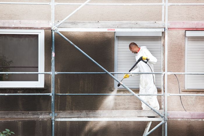 Un ouvrier nettoie une façade au Kärcher